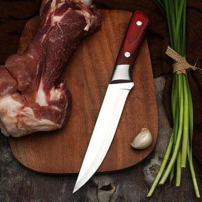 Couteau à désosser deposé sur planche de bois os de boeuf et oignon vert