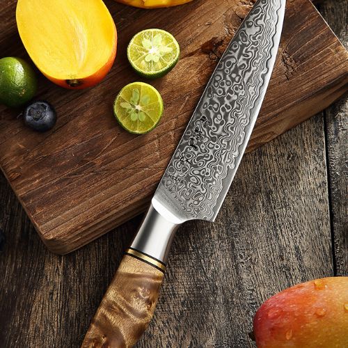 couteau japonais damas présenté avec des quartiers de citron 